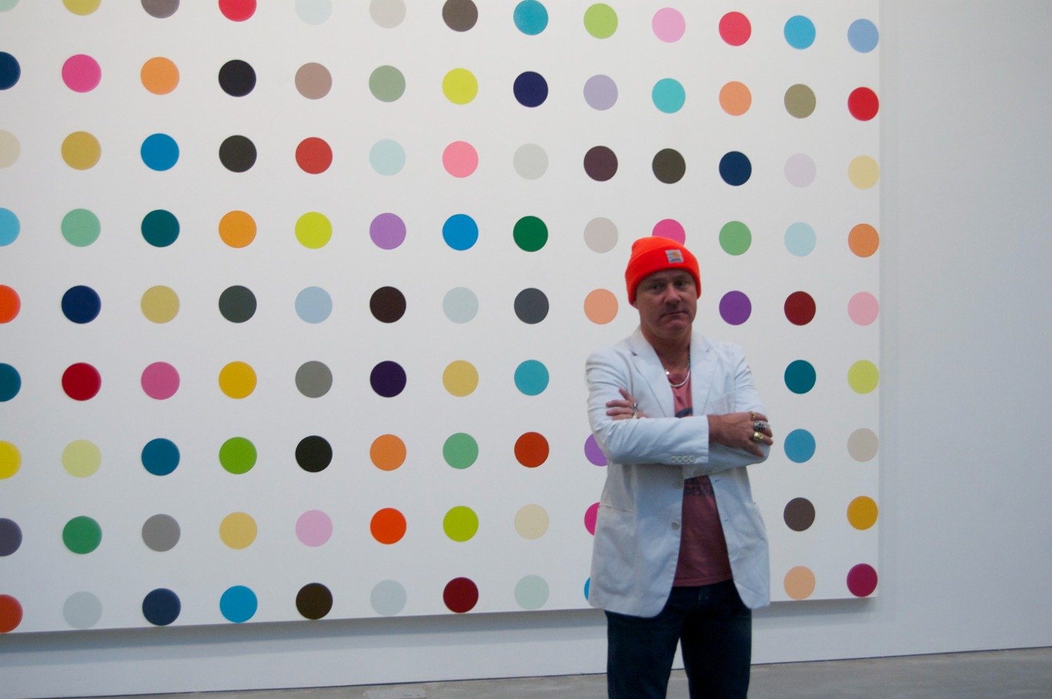 Photo of Damien Hirst NFT standing in front of art