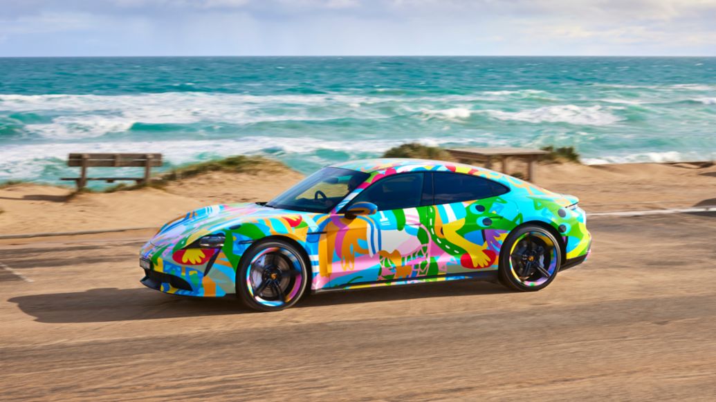 Porsche Taycan driving through a beach 