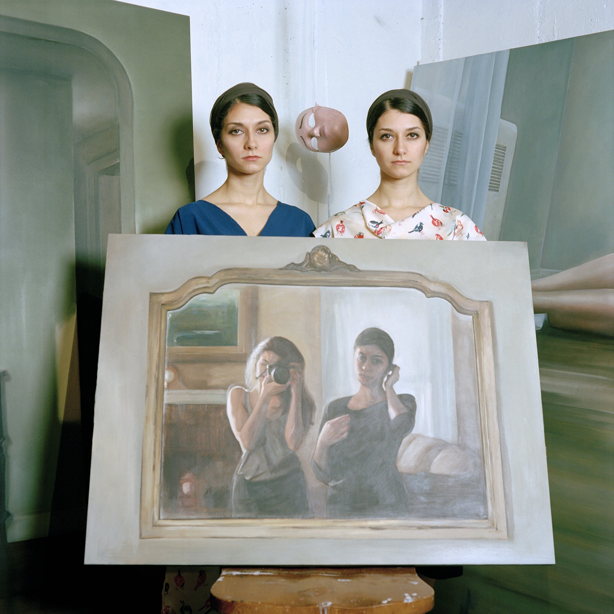 Photograph of twins holding a painting of themselves, taken by top NFT photographer Justin Aversano