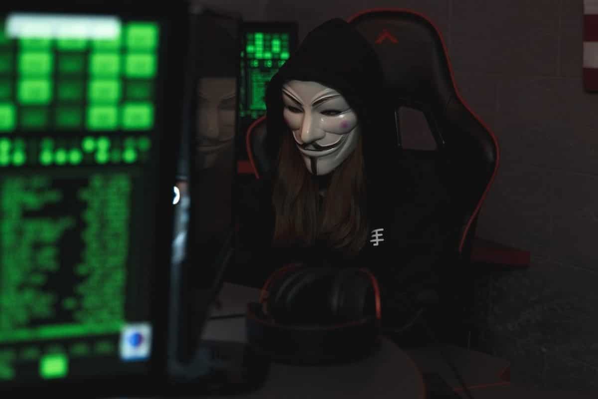 A masked hacker attempting to hack a system