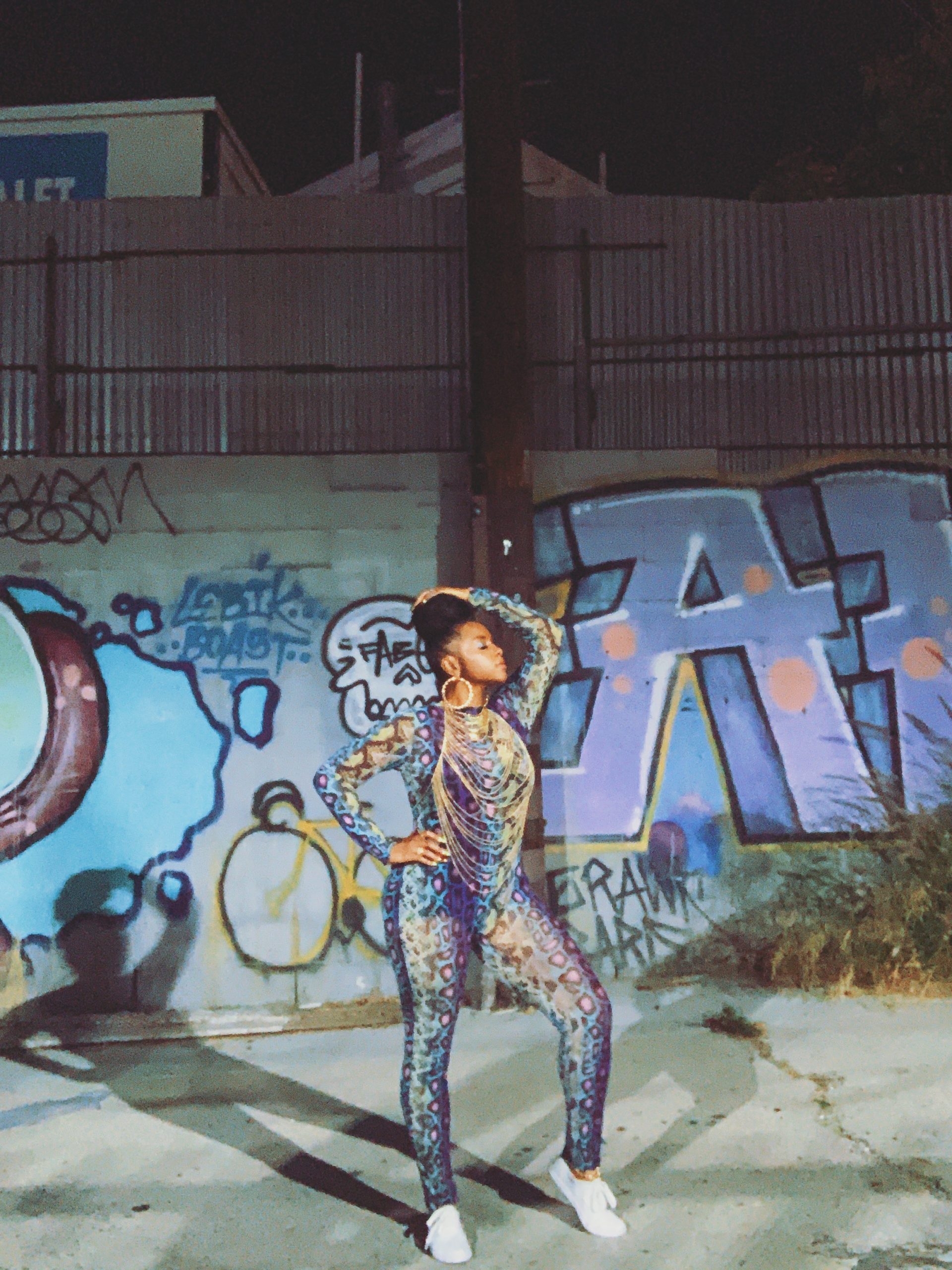 BTS Photo of NFT Artist Latahsha posing in front of graffiti