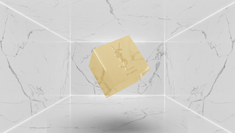 The image shows a gold cube engraved with YSL, signifying Yves Saint Laurent Beauté's entry into the NFT space.
