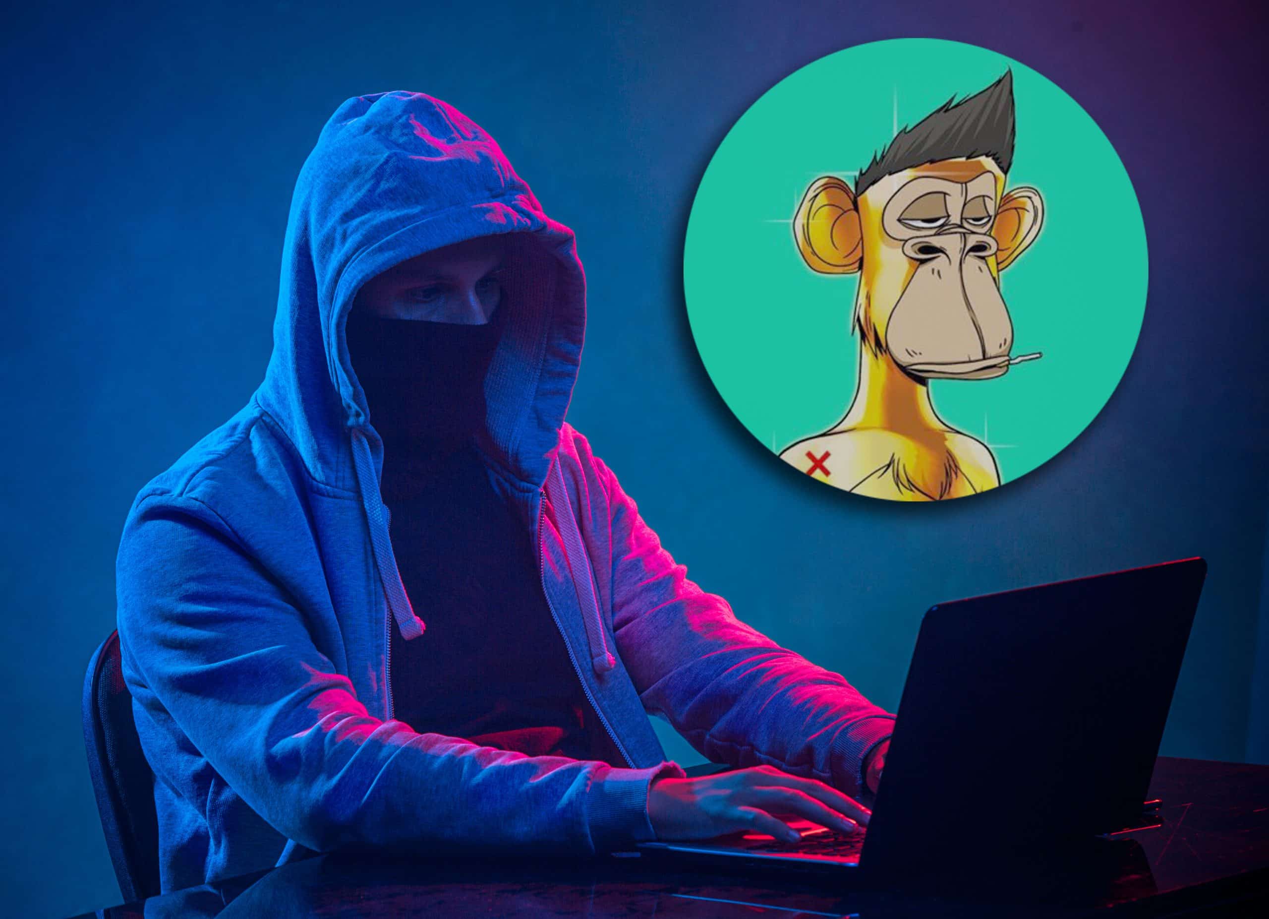 Hooded computer hacker stealing information with laptop on colored studio background