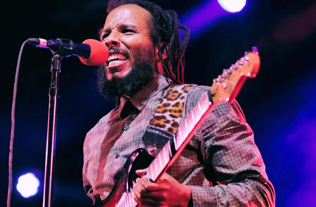 imagen del músico de reggae Ziggy Marley tocando la guitarra y cantando durante un concierto en vivo
