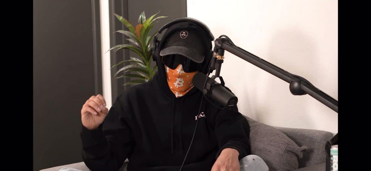 A man in a black hoodie wears shades and bitcoin mask. It's FrankDeGods before the FrankDeGods doxx.