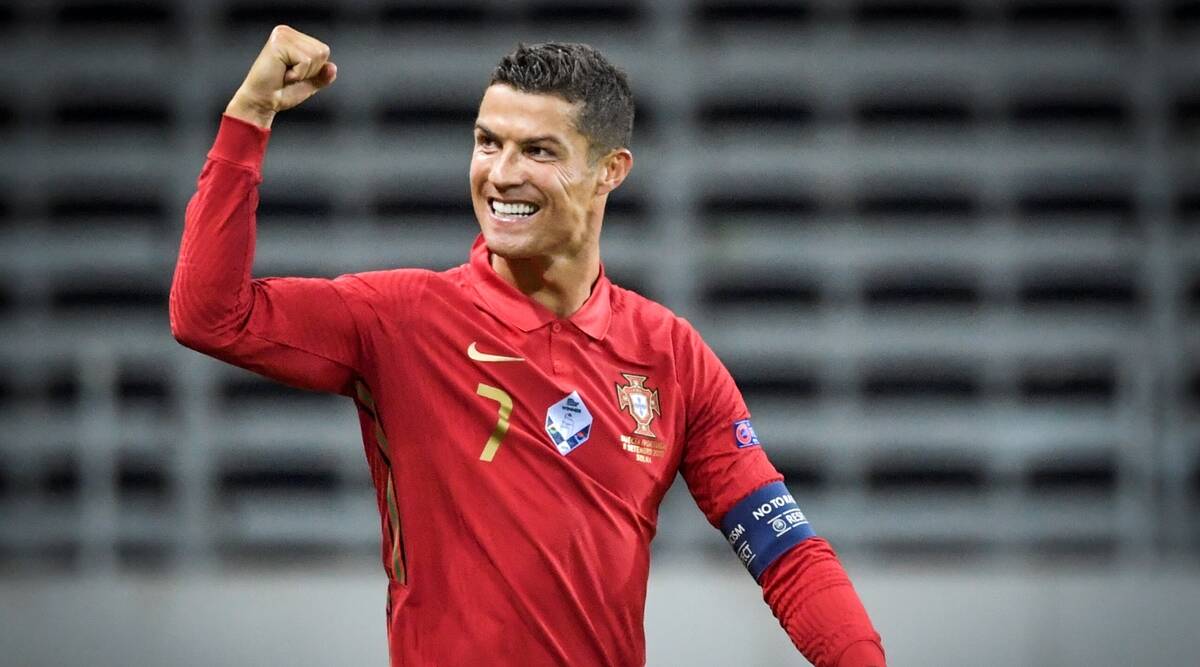 a picture of Cristiano Ronaldo wearing a Portugal jersey and holding a fist up in victory