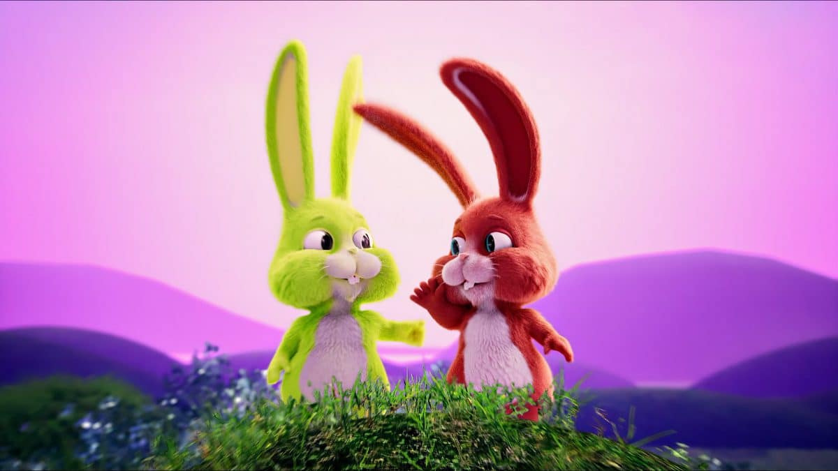 Two animated bunnies stand atop a hill at sunset.