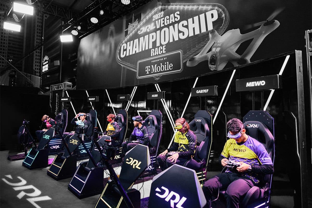 Seis competidores se sientan en sillas durante el Campeonato de la Liga de Carreras de Drones.
