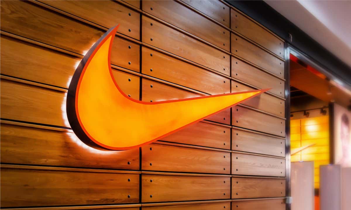 An orange Nike logo lit up against a wooden background.