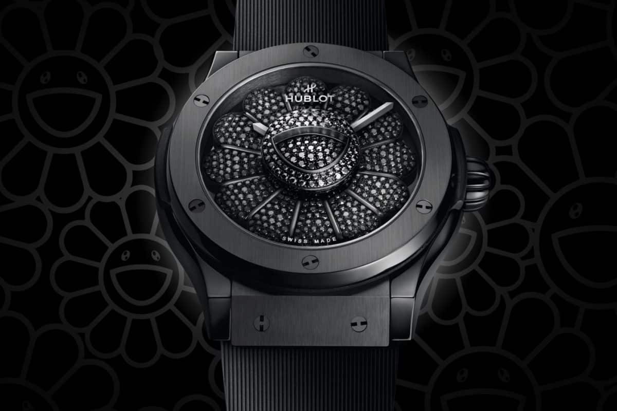 A black hublot watch is pictured against a black background.