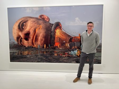 Beeple posing with a piece from his EVERYDAYS collection