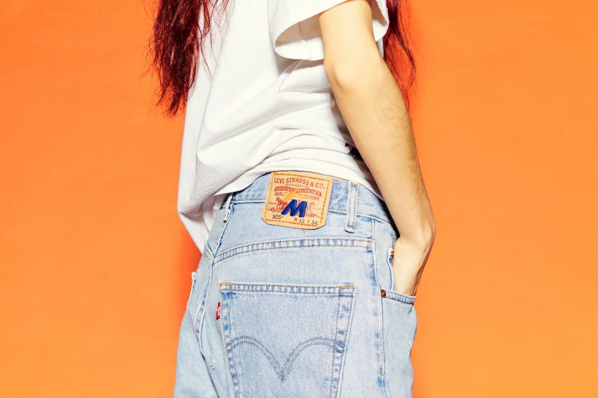 A picture of a model wearing MNTGE Fruits & Veggies digital wearables Levi's jeans. 