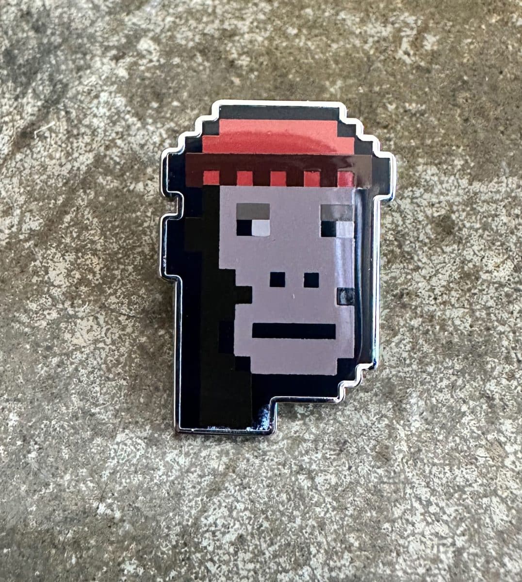 image of gmoney pin 0 a pixelated monkey face wearing a red beanie