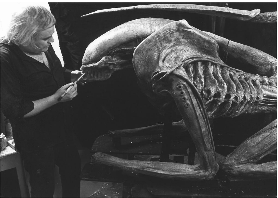 A picture of the artist H.R. Giger with his Xenomorph Sculpture.
