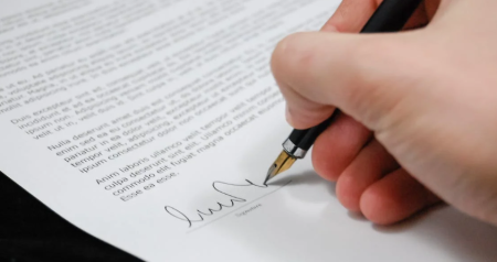 image of someone signing papers to illustrate zachxbt lawsuit