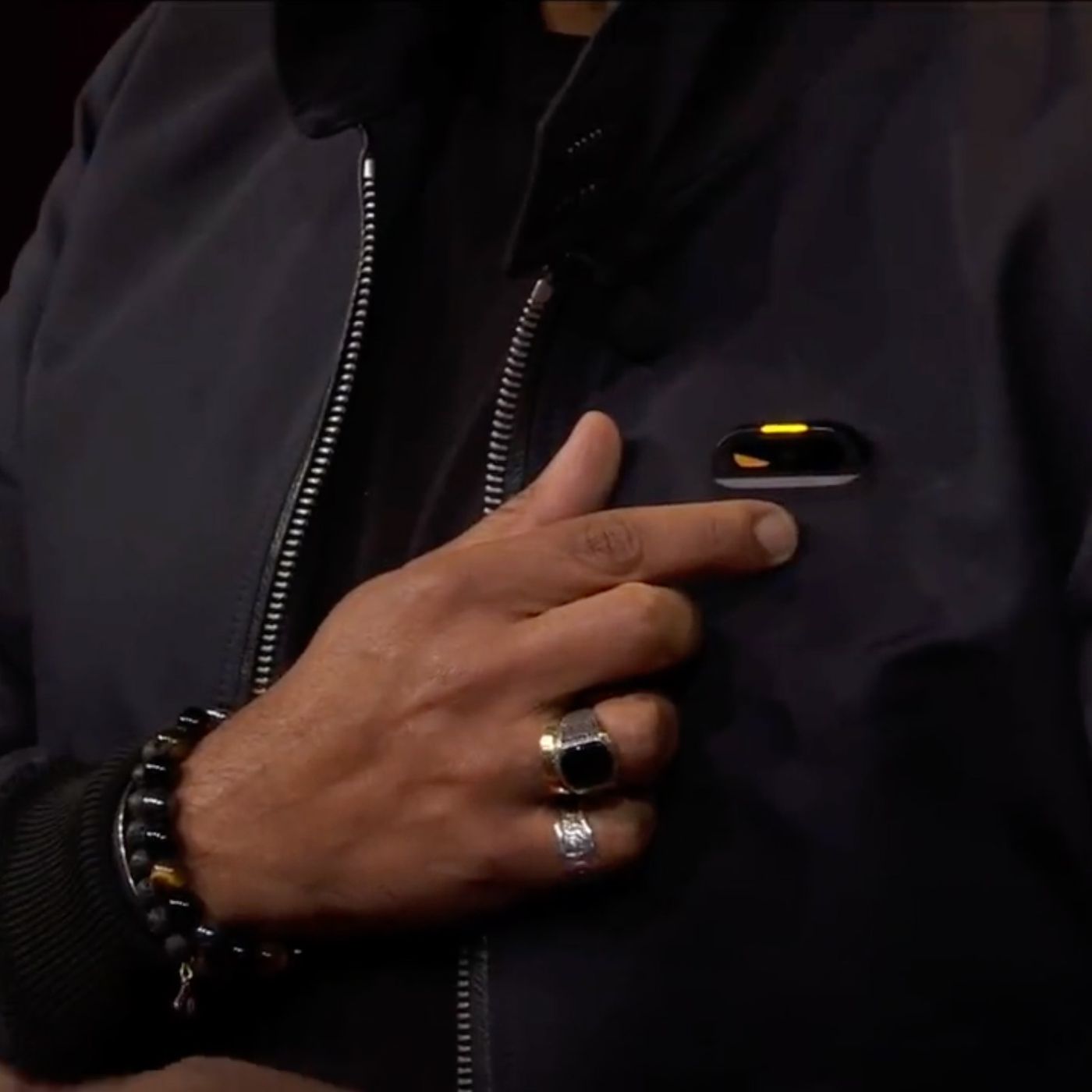 humane ai pin, attached to a black jacket